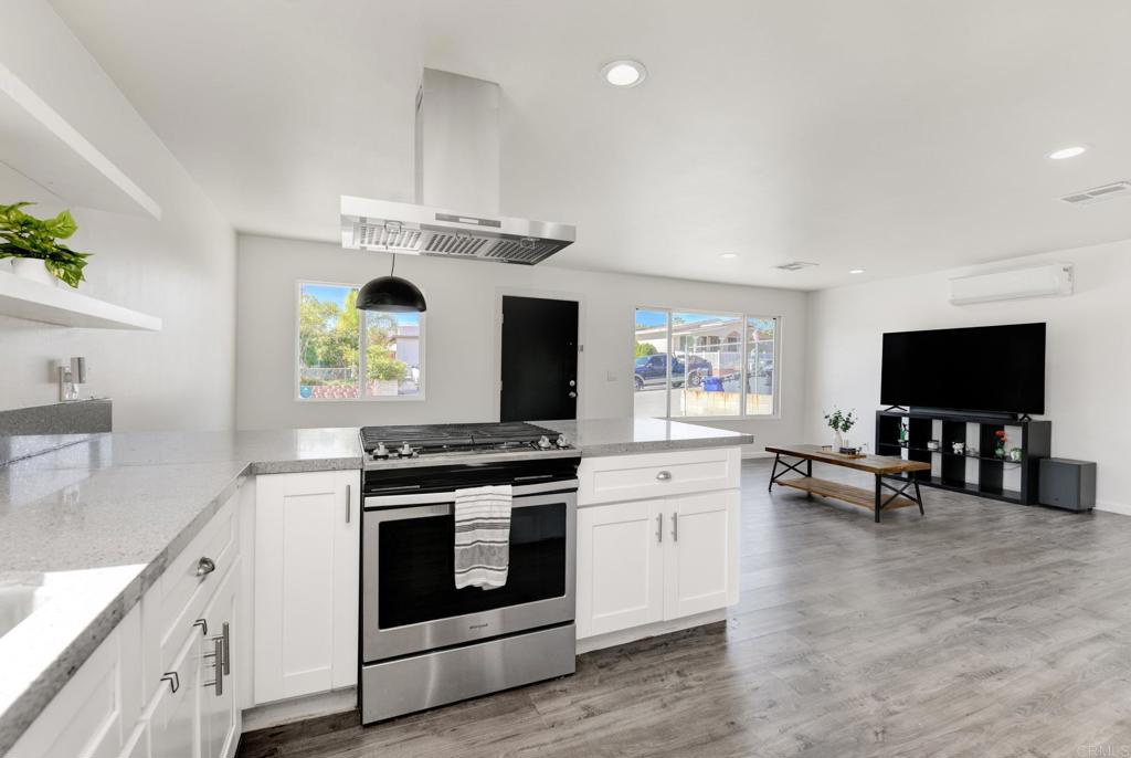 611 San Juhn Street Spring Valley, CA 91977 - Photo 3 of 25 a kitchen with stainless steel appliances a stove a sink cabinets and a wooden floor