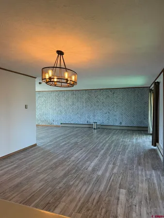 a kitchen with stainless steel appliances granite countertop a refrigerator a sink and wooden floors