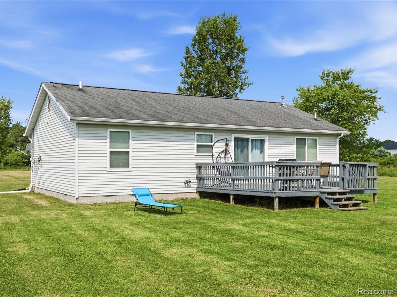 8884 Kilgore Road Avoca, MI 48006 - Photo 24 of 31 Rear exterior featuring light-colored siding, a gray shingle roof, and a multi-level wooden deck with steps