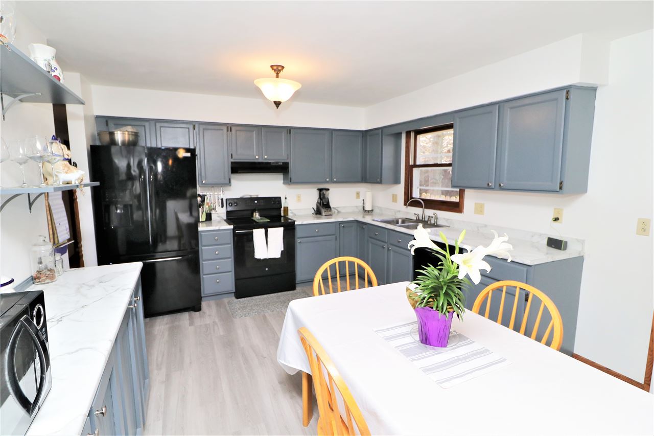 16214 Anderson Road Davis, IL 61019 - Photo 6 of 27 a kitchen with stainless steel appliances wooden floors a dining table and chairs