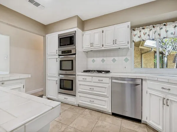 a kitchen with white cabinets and white appliances