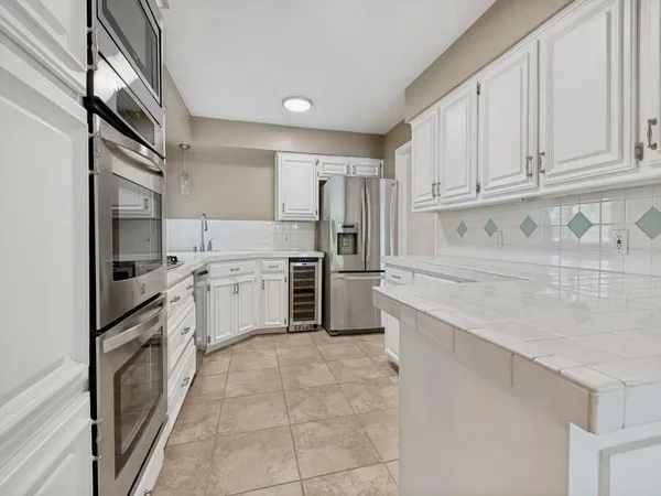 a kitchen with white cabinets and a window