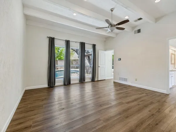 a spacious white bathroom with a granite countertop tub sink and mirror