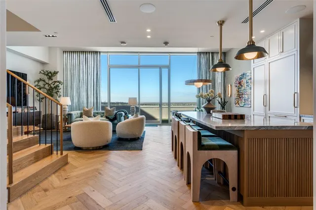 a living room with furniture a wooden floor and a large window