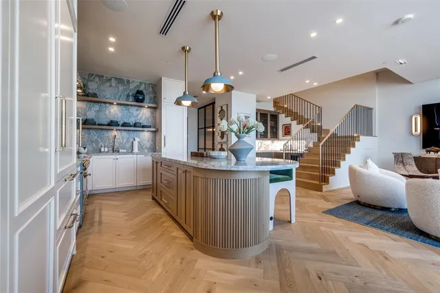 a kitchen island with stainless steel appliances kitchen island granite countertop a table and a refrigerator
