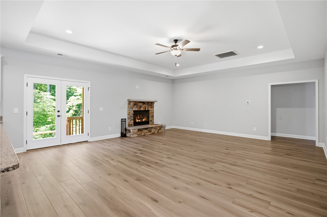 912 Watercrest Road West Union, SC 29696 - Photo 4 of 49 This bright living space features hardwood flooring and a charming stone fireplace, ideal for comfort and style.