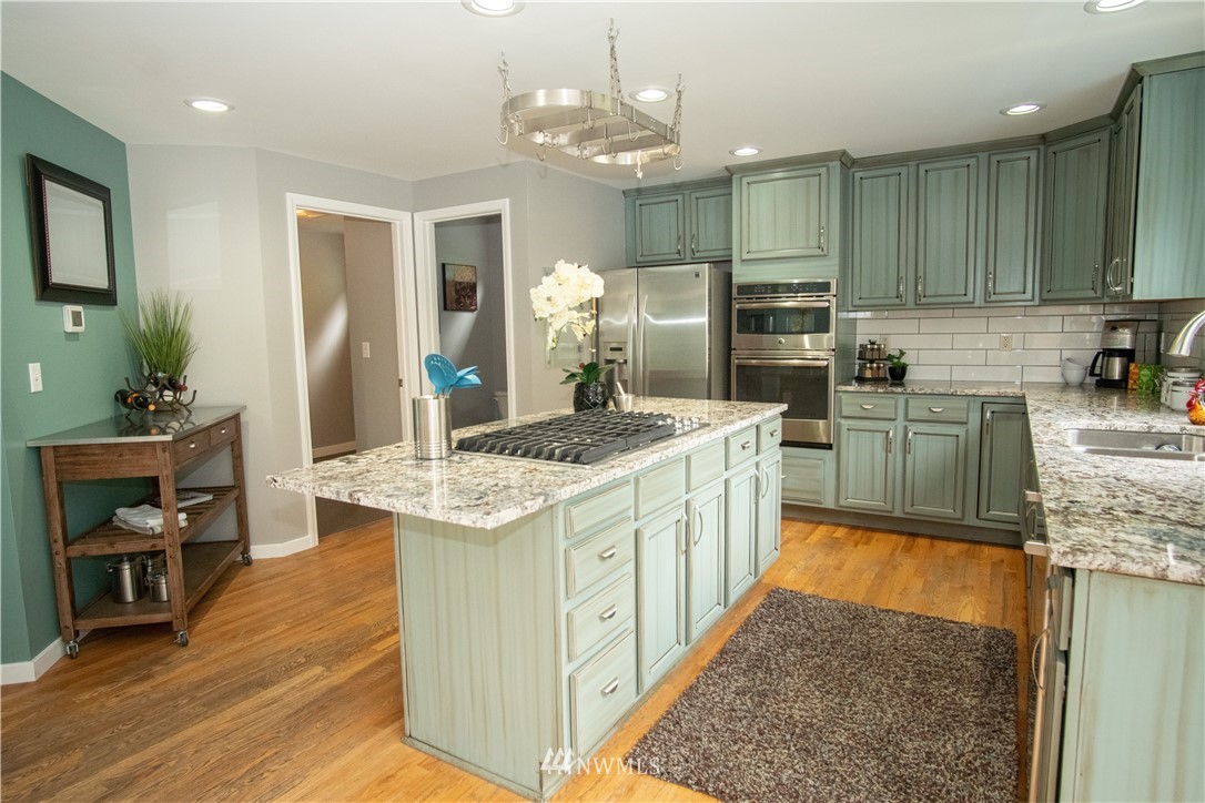7215 South Rustic Road Seattle, WA 98178 - Photo 14 of 32 a kitchen with stainless steel appliances granite countertop a sink stove and refrigerator