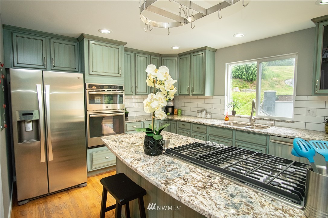 7215 South Rustic Road Seattle, WA 98178 - Photo 15 of 32 a kitchen with stainless steel appliances granite countertop a sink and a refrigerator
