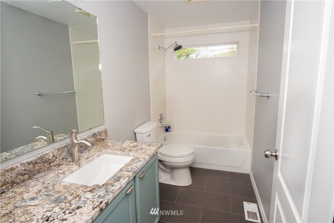 7215 South Rustic Road Seattle, WA 98178 - Photo 27 of 32 a bathroom with a granite countertop sink a toilet and shower