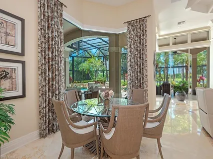 a dining room with furniture a chandelier and wooden floor