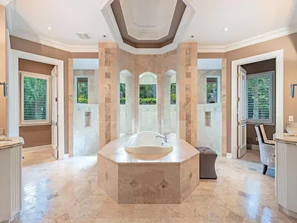 a spacious bathroom with a tub and large windows