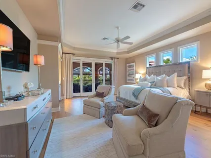 a living room with furniture a flat screen tv and a floor to ceiling window