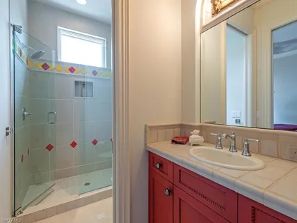 a bathroom with a granite countertop sink and a mirror
