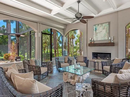 a living room with patio furniture and a large window
