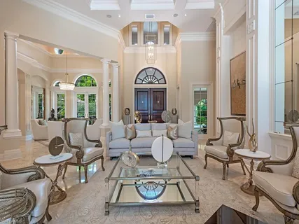 a living room with couches a fireplace and a chandelier