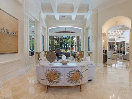 a living room with furniture a chandelier and a large window