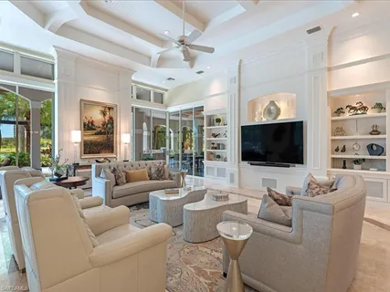 a living room with furniture a flat screen tv and a large window