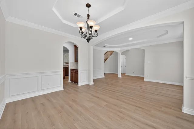 a view of a livingroom with a chandelier wooden floor and a chandelier