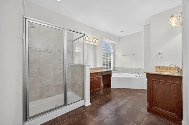 a bathroom with a tub shower sink and mirror