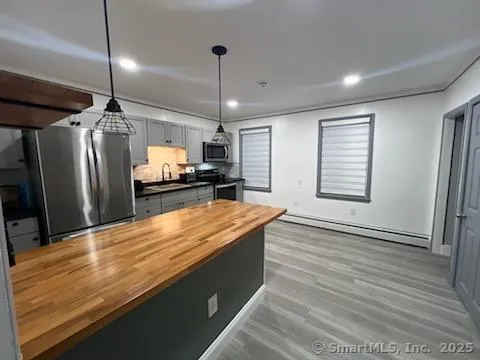 a large kitchen with kitchen island a counter space a sink appliances and cabinets