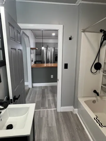 a bathroom with a tub sink and mirror
