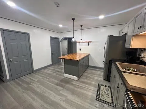 a kitchen with stainless steel appliances granite countertop a refrigerator a sink and a stove