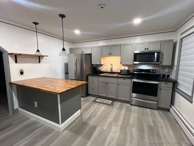 a kitchen with kitchen island a sink appliances and cabinets