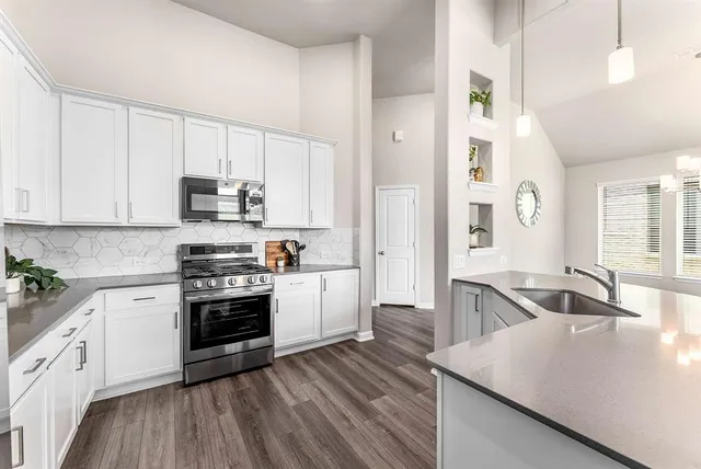 a kitchen with stainless steel appliances granite countertop a sink stove and refrigerator