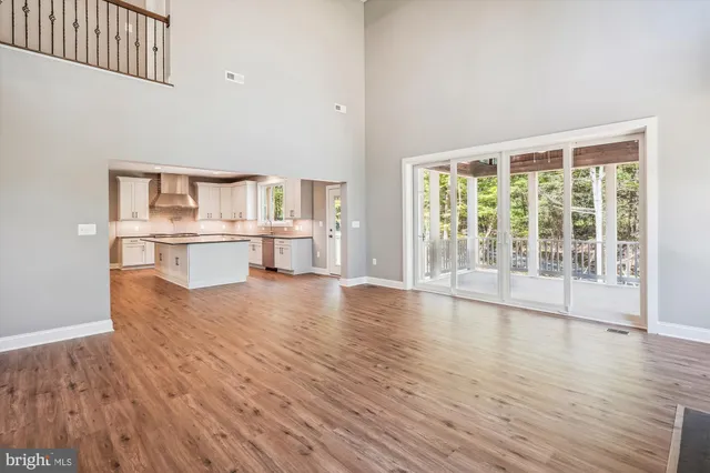 a view of empty room with fireplace and wooden floor