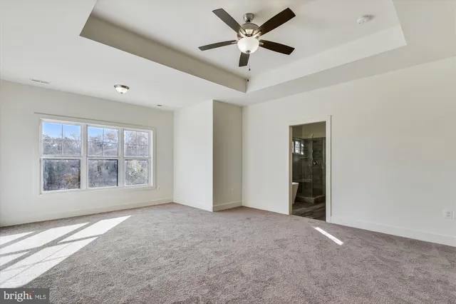 an empty room with a ceiling fan and a window