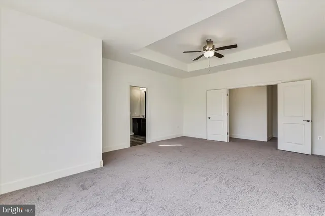 an empty room with a ceiling fan and a window
