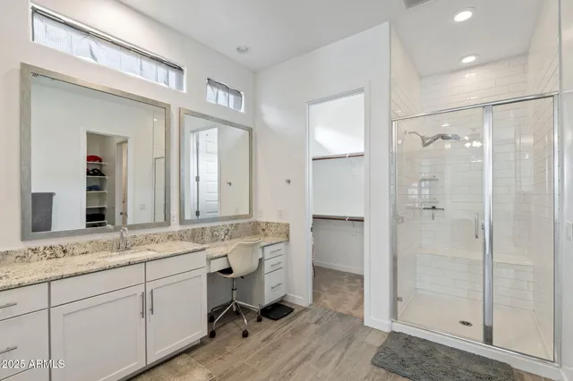 a bathroom with a granite countertop sink mirror and a shower