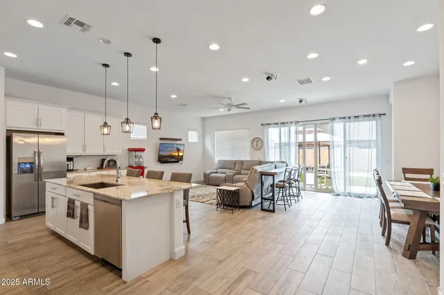 a kitchen that has a lot of cabinets stainless steel appliances and wooden floor