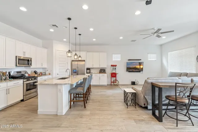 a living room with stainless steel appliances kitchen island granite countertop furniture and a dining table with kitchen view