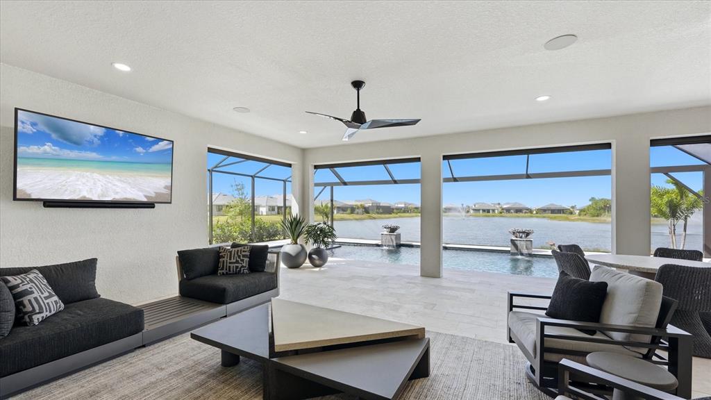 12866 Pinnacle Lane Venice, FL 34293 - Photo 14 of 96 a living room with furniture ceiling fan and a floor to ceiling window