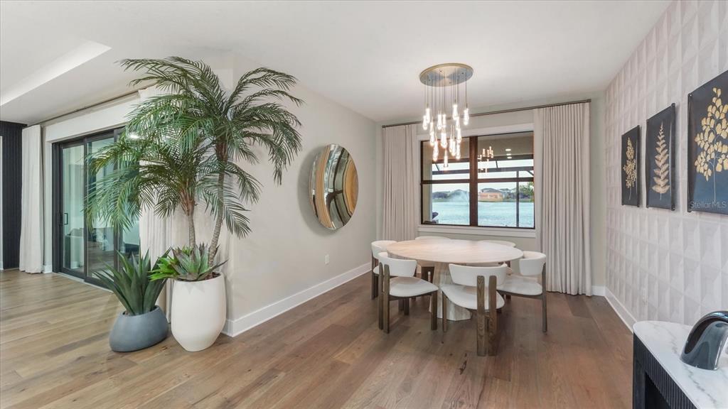 12866 Pinnacle Lane Venice, FL 34293 - Photo 47 of 96 a dining room with furniture potted plants and wooden floor