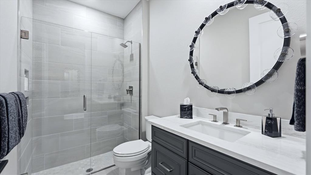 12866 Pinnacle Lane Venice, FL 34293 - Photo 64 of 96 a bathroom with a sink a toilet and a mirror