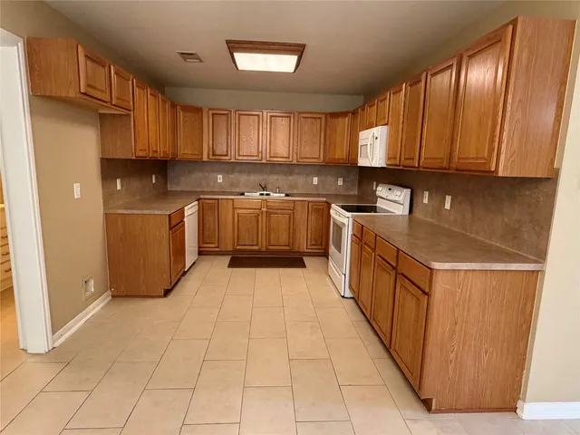 a kitchen with stainless steel appliances granite countertop a stove top oven a sink a counter space and cabinets
