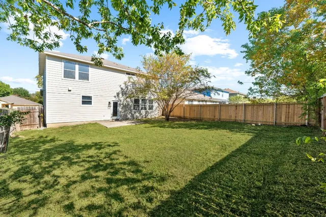a view of a backyard with large trees