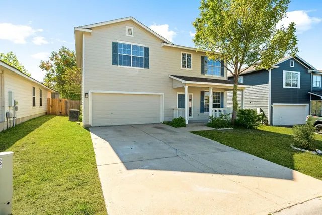 a front view of a house with a yard and trees
