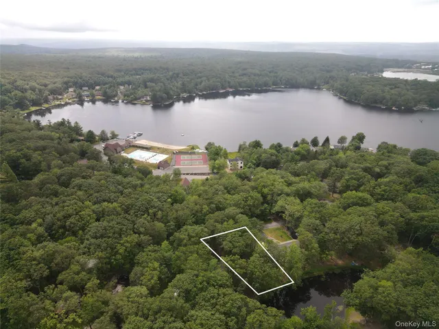 an aerial view of ocean and residential houses with outdoor space