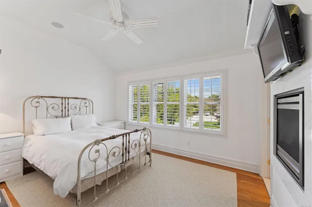 a bedroom with a bed a flat screen tv and window