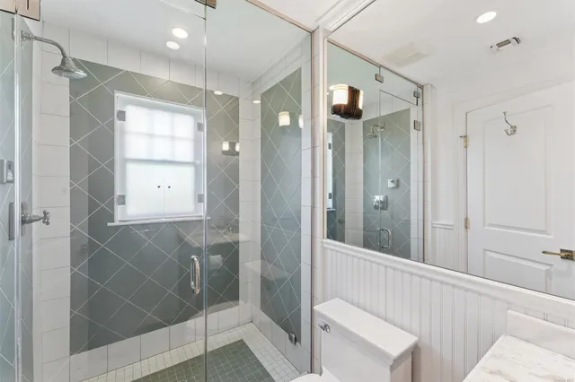 a bathroom with a glass shower door and a sink