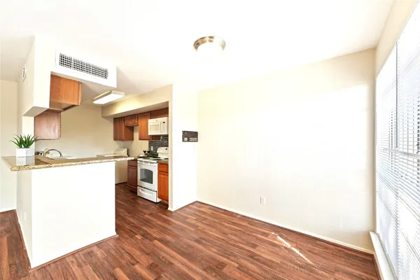 a kitchen with a wooden floor and a refrigerator