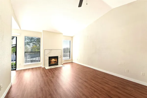 a view of a livingroom with wooden floor and a fireplace