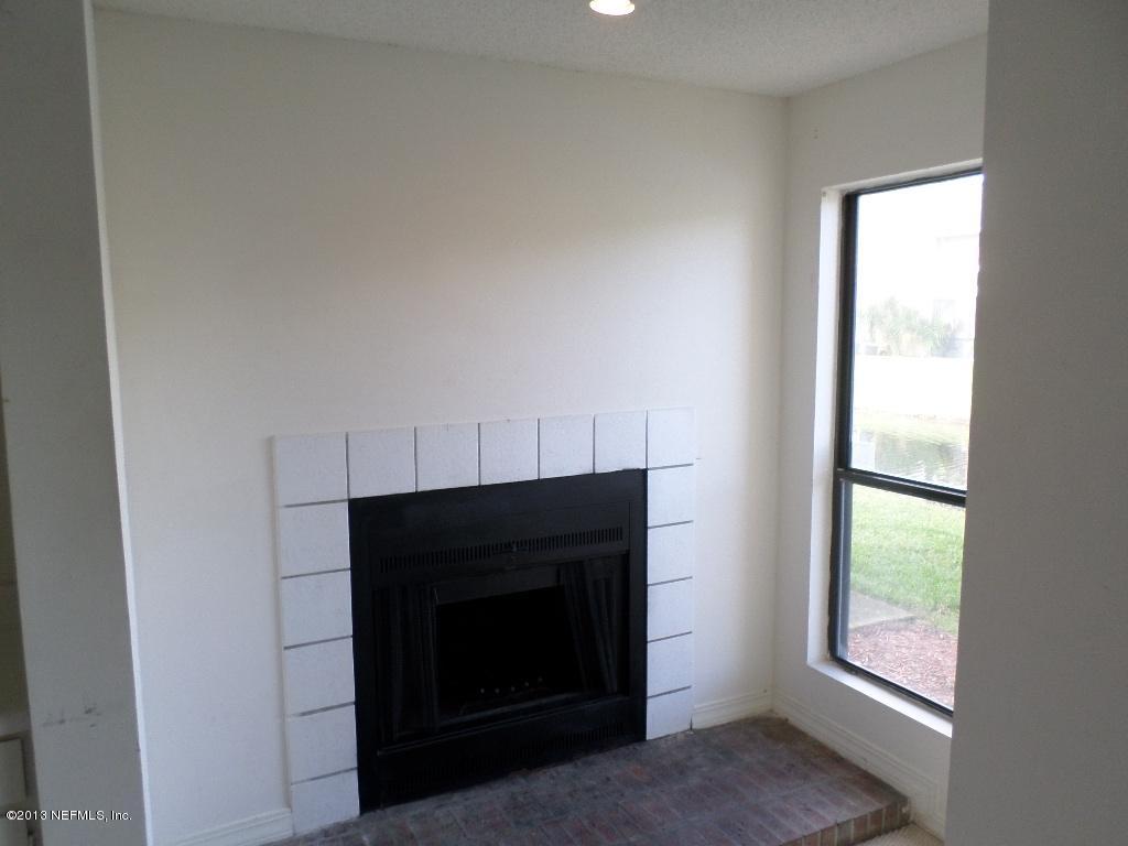 10200 Belle Rive Boulevard, Unit 69 Jacksonville, FL 32256 - Photo 7 of 17 a living room with a fireplace and a window