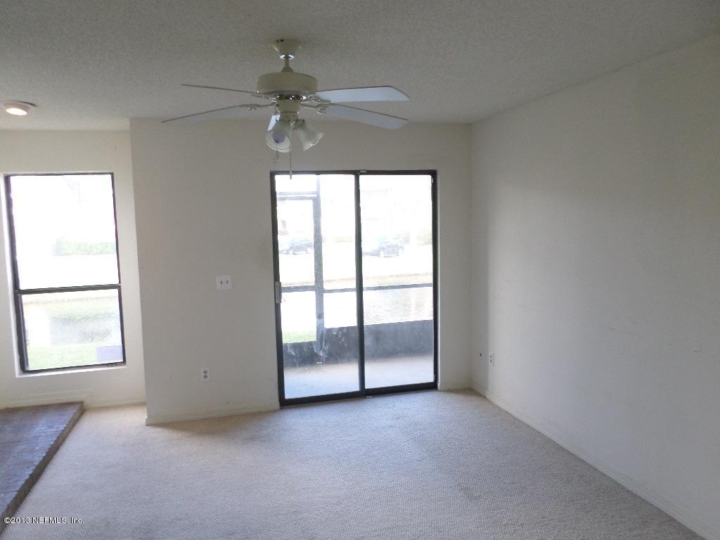 10200 Belle Rive Boulevard, Unit 69 Jacksonville, FL 32256 - Photo 8 of 17 an empty room with chandelier fan and windows