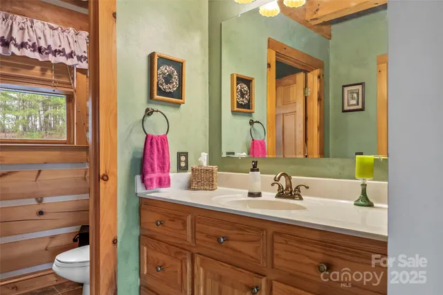 a bathroom with a sink vanity mirror and toilet