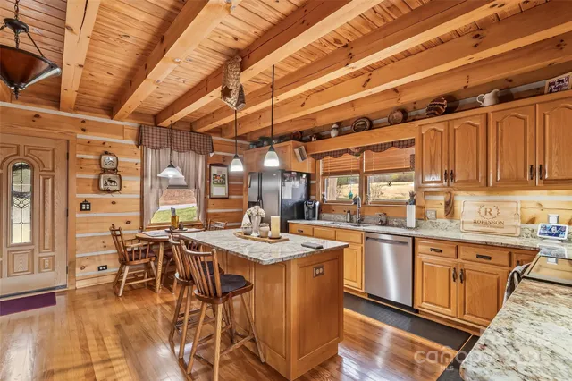 a open kitchen with stainless steel appliances granite countertop a sink a stove and cabinets