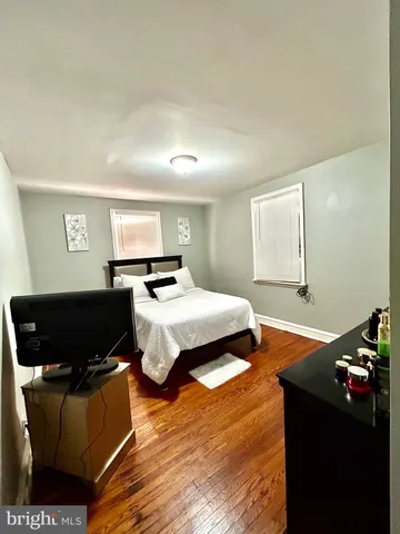 a bedroom with a bed and dresser with mirror